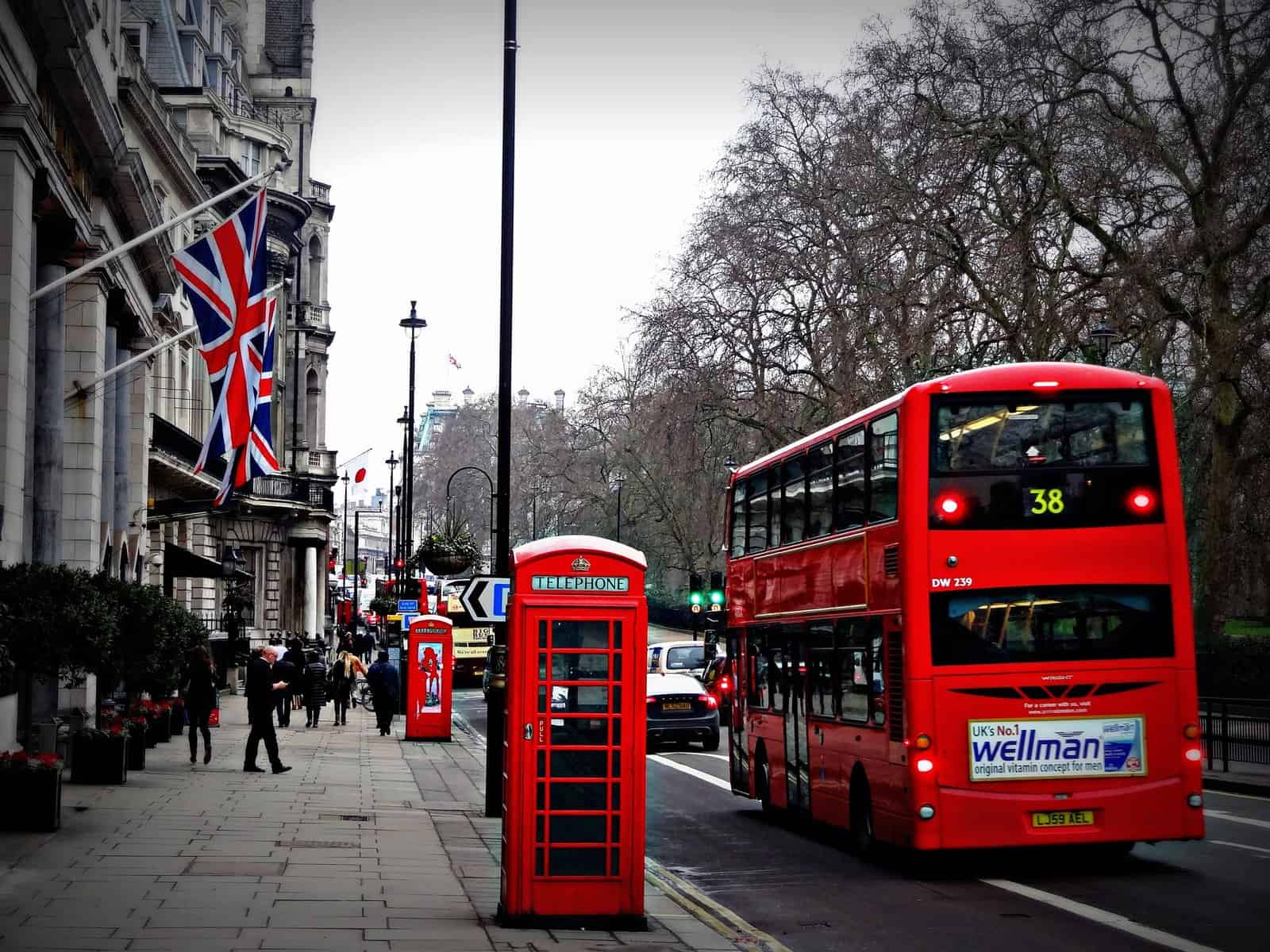 Rue de Londres en hiver avec une cabine téléphonique rouge, un autobus rouge à impériale et un drapeau britannique sur une façade