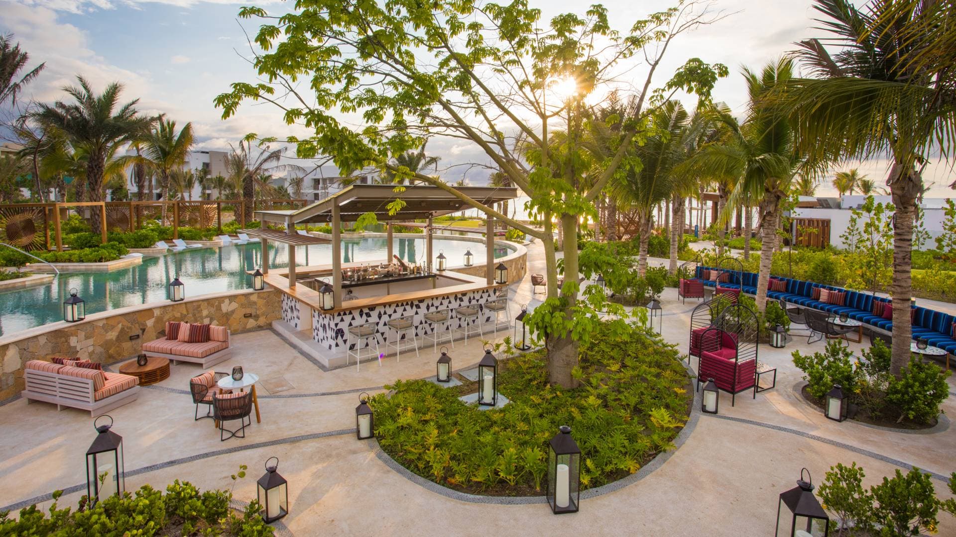 Pool and outdoor bar surrounded by palm trees at a resort
