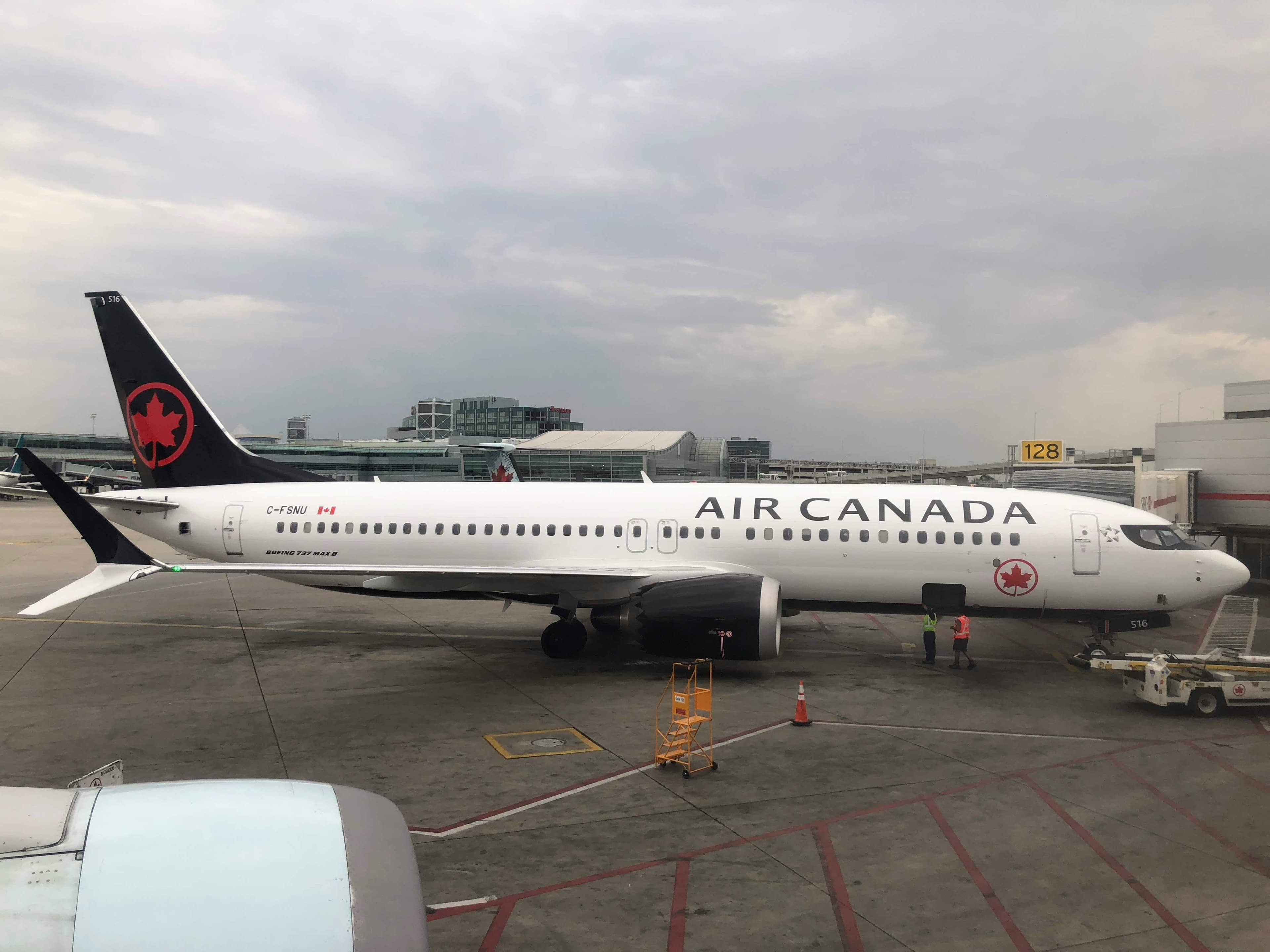 White and black Air Canada aircraft parked on the apron.