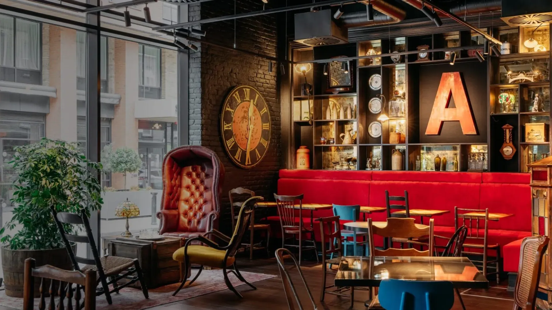 Hall de l'hôtel Ruby Molly à Dublin, avec banquettes rouges, tables et chaises dépareillées et étagères garnies de bibelots