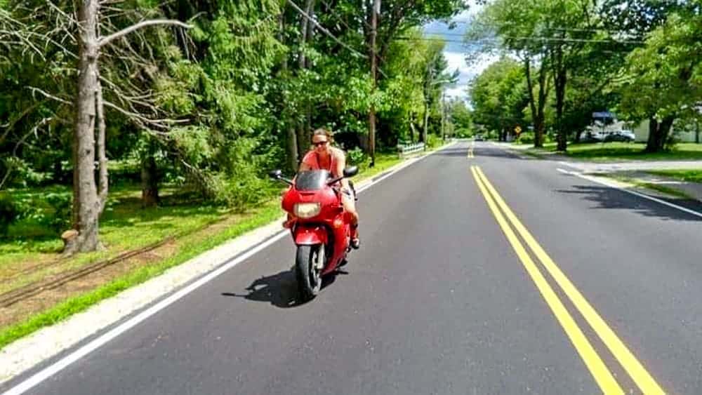 road trip en moto, motarde sur la route, femme en moto rouge