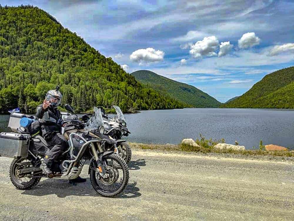 2 motos arrêtées pour observer un paysage avec un lac.