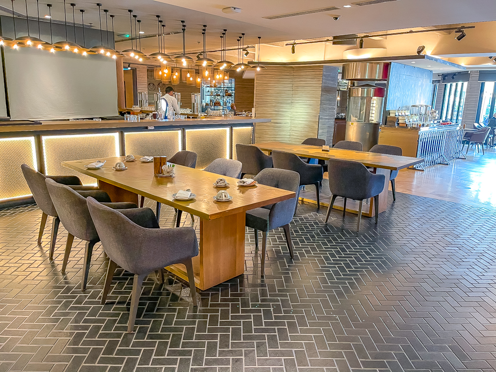 Salle de restaurant principale avec décor moderne et tables en bois au le meridien dubai hotel conference