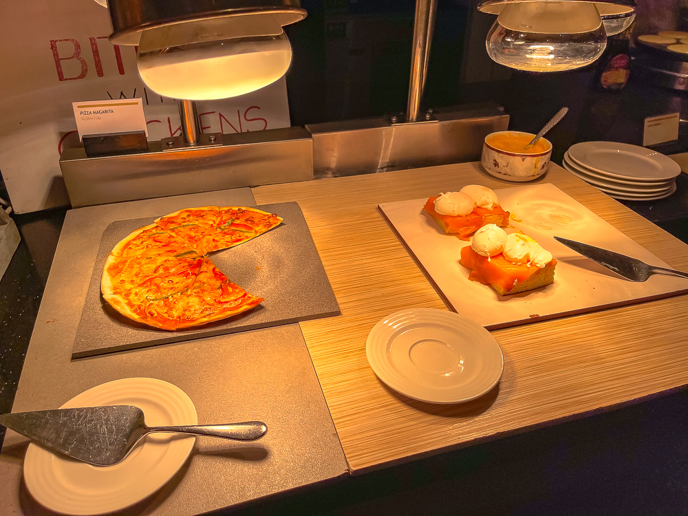 Pizza Margherita fraîchement préparée et saumon fumé sur la station buffet du le meridien dubai hotel conference