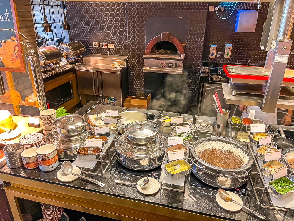 Station de cuisine live avec four à pizza et plats chauds au restaurant du le meridien dubai hotel conference