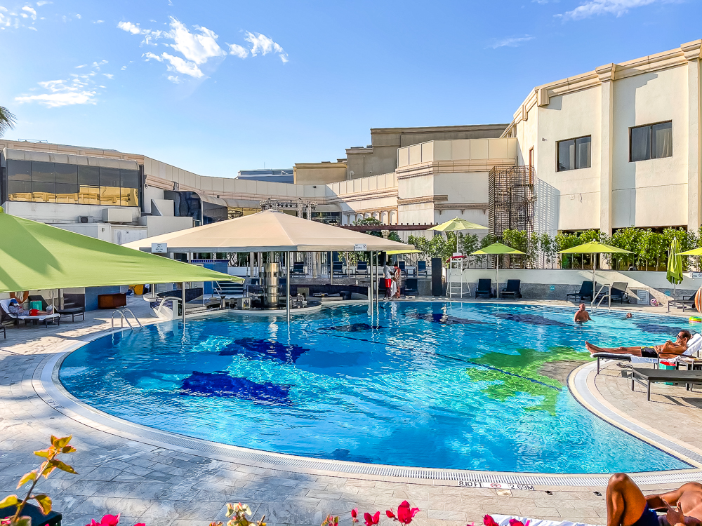 Piscine extérieure entourée de transats au le meridien dubai hotel conference