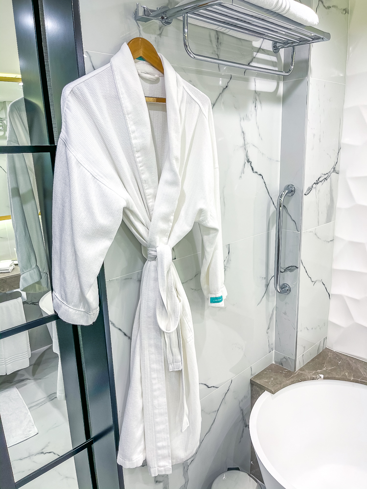 Peignoirs blancs suspendus dans la salle de bain du le meridien dubai hotel conference