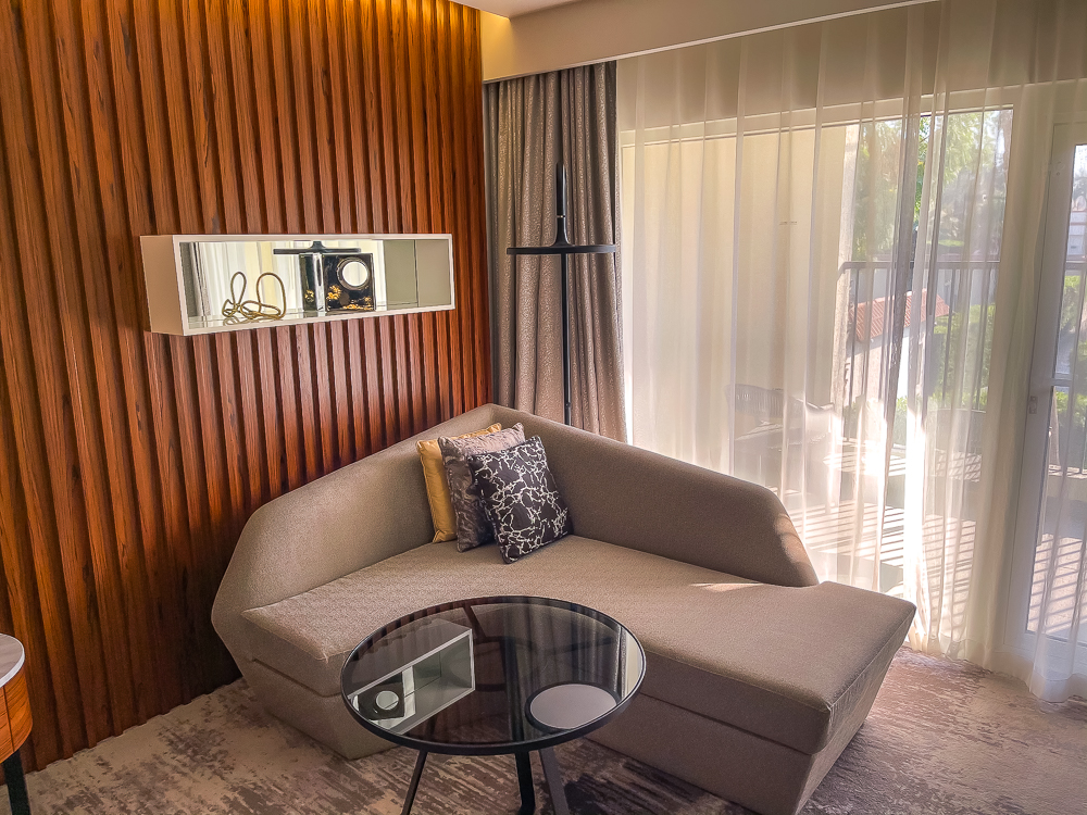 Coin salon moderne avec canapé gris et table basse dans une chambre du le meridien dubai hotel conference