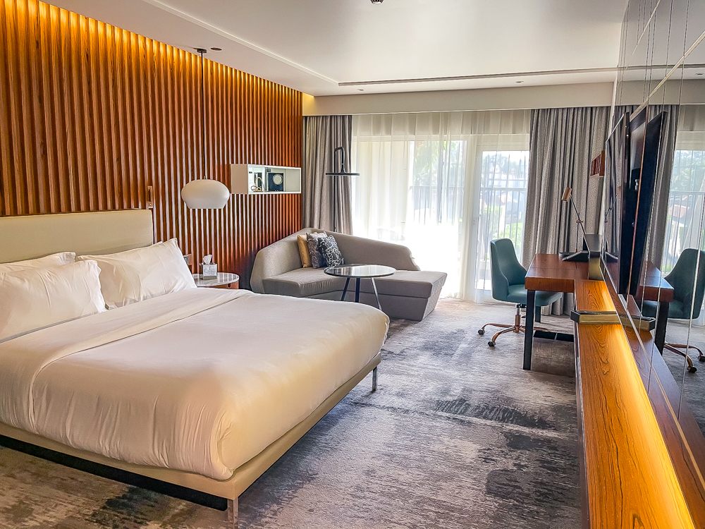 Chambre deluxe spacieuse avec lit king size et salon du le meridien dubai hotel conference avec design contemporain