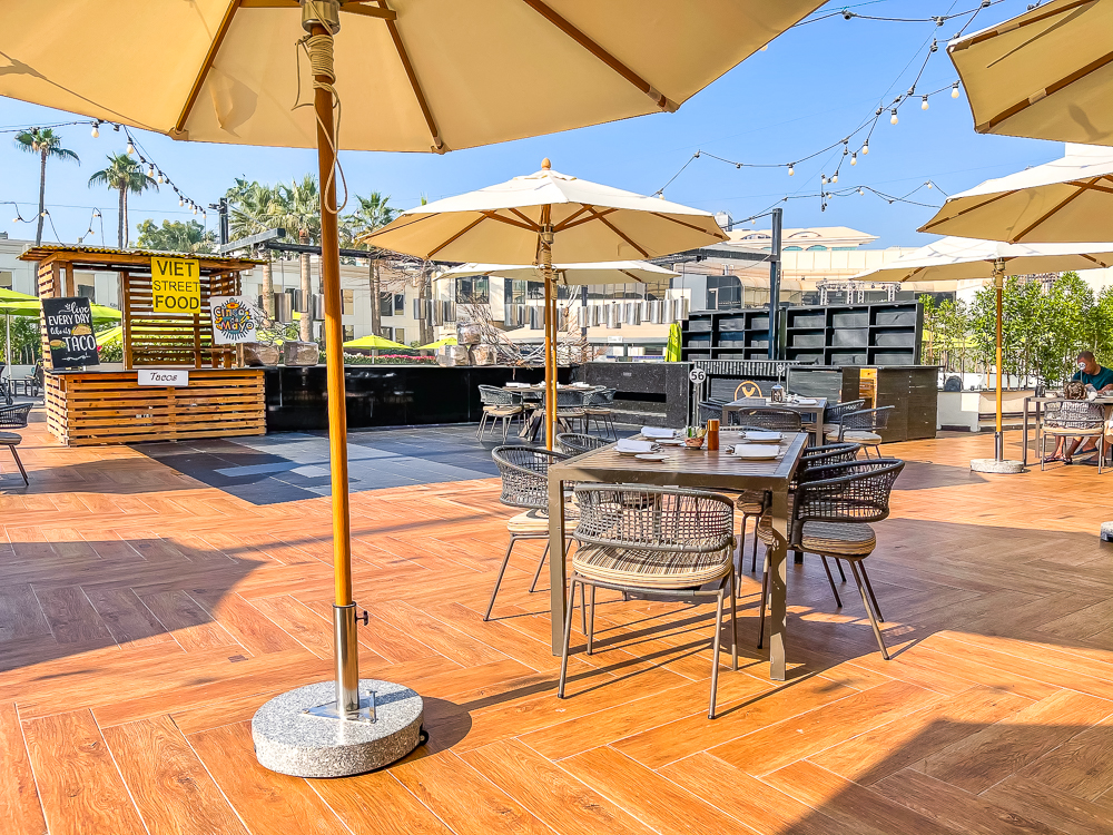 Terrasse extérieure ensoleillée avec parasols et tables pour le petit-déjeuner au le meridien dubai hotel conference