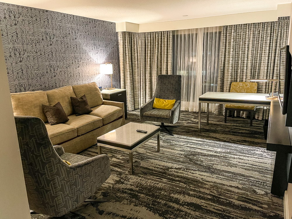 Salon de suite avec grandes fenêtres et coin repas au hyatt regency vancouver