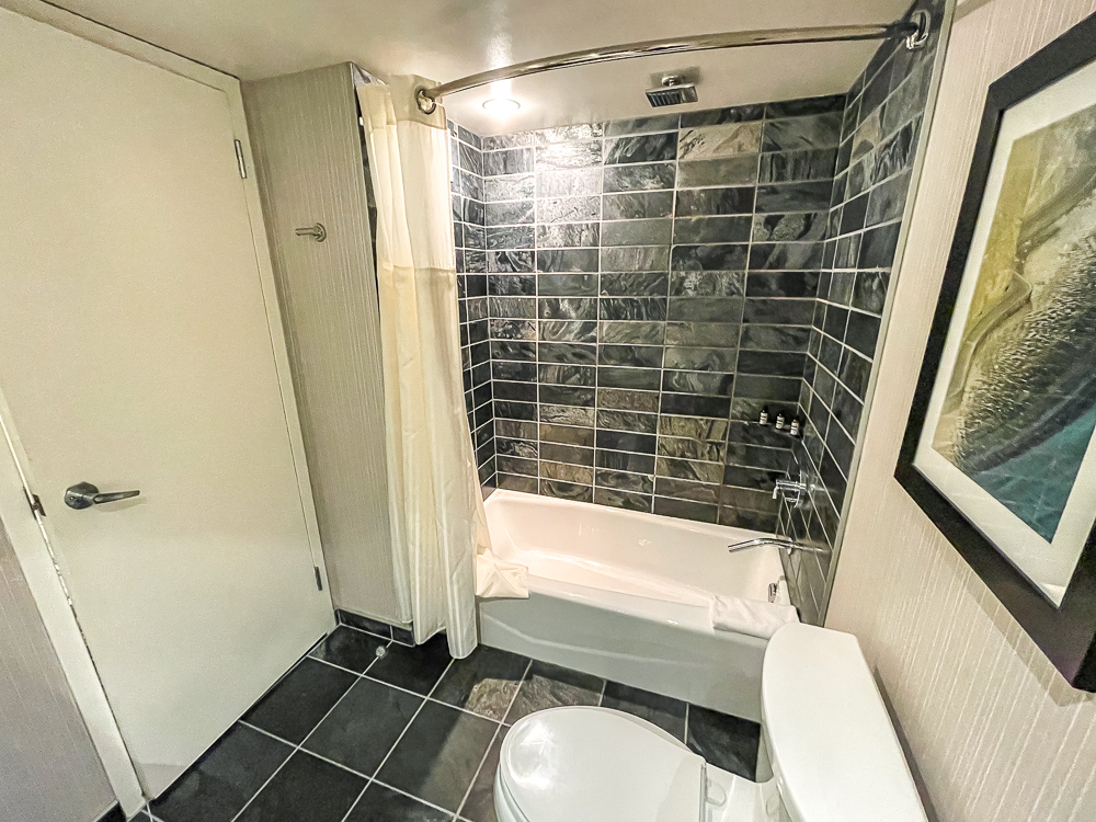 Salle de bain moderne au hyatt regency vancouver avec baignoire et carrelage noir effet marbre