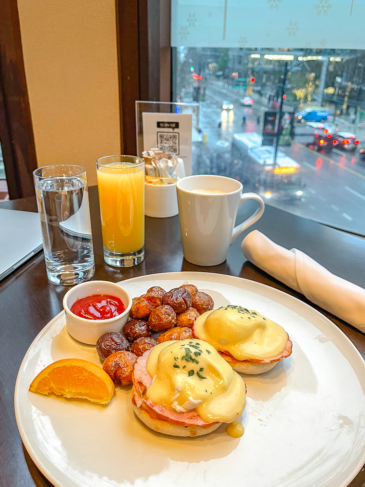 Petit-déjeuner élégant servi au restaurant du hyatt regency vancouver avec œufs Benedict et pommes de terre rôties