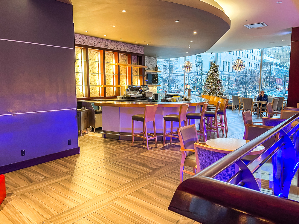 Bar restaurant moderne du hyatt regency vancouver avec sièges en cuir et éclairage d'ambiance violet