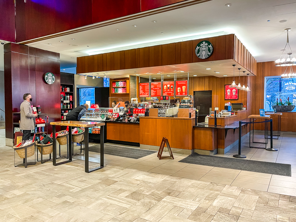 Café Starbucks dans le lobby du hyatt regency vancouver avec comptoir en bois et menu affiché