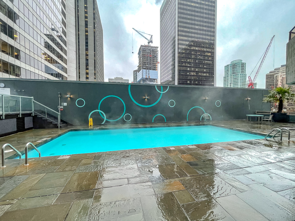 Piscine extérieure sur terrasse du hyatt regency vancouver avec vue sur les gratte-ciel du centre-ville