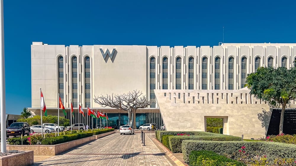 Façade imposante du w muscat hotel avec architecture contemporaine inspirée des traditions omanaises sous ciel bleu