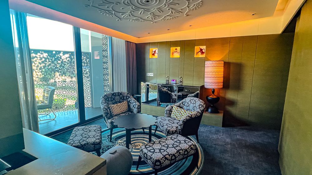 Salon élégant d'une suite premium du w muscat avec mobilier design et bar privé sous plafond sculpté décoratif