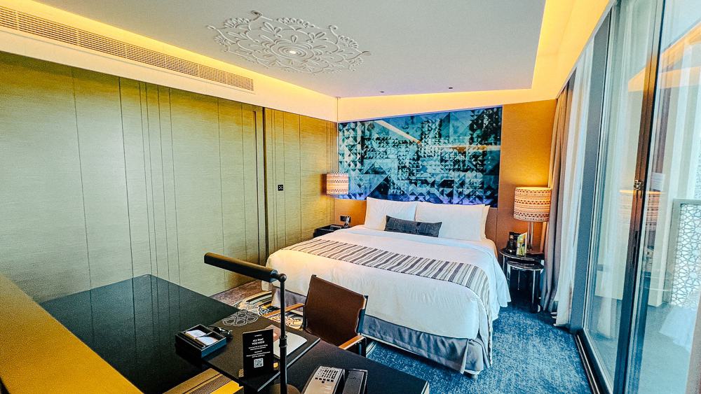 Chambre Marvelous du w muscat avec tête de lit bleue géométrique, lit king-size et vue sur l'extérieur, décoration moderne