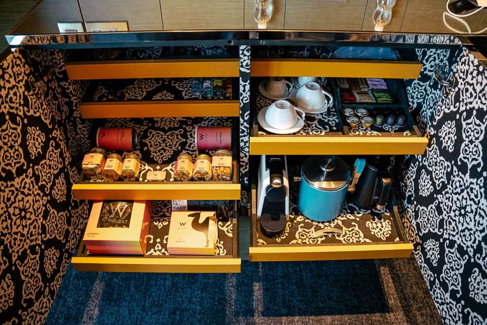 Station thé et café du w muscat avec motifs décoratifs, tasses blanches et accessoires de service dans un meuble design