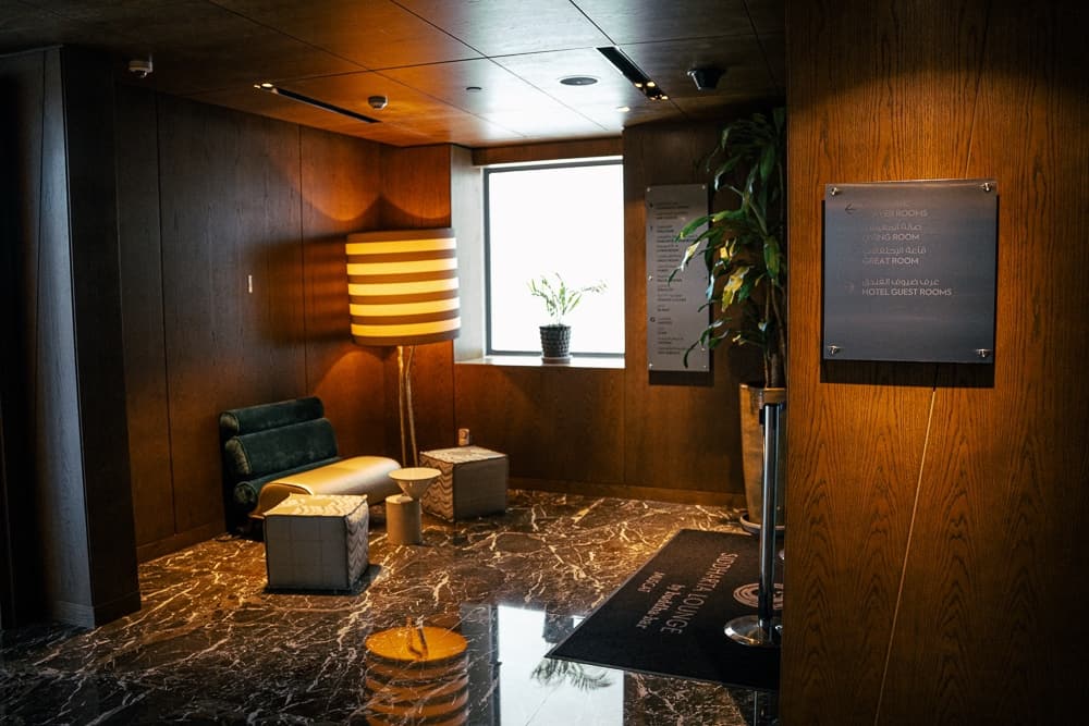 Salon privé du w muscat avec mobilier design, sol en marbre brun et éclairage tamisé, ambiance luxueuse et moderne