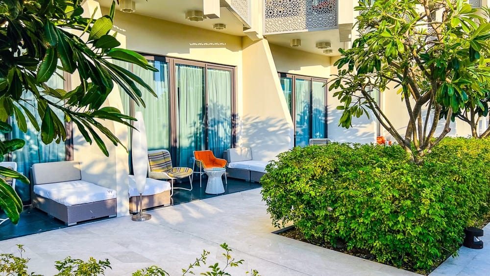 Terrasse panoramique du w muscat avec fauteuils design, baies vitrees et vue sur mer et palmiers tropicaux