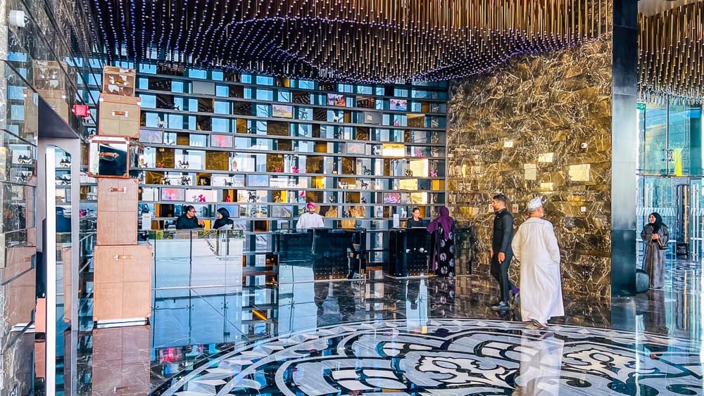 Hall central du w muscat avec mur d'ecrans interactifs, sol marbre geometrique et plafond design impressionnant