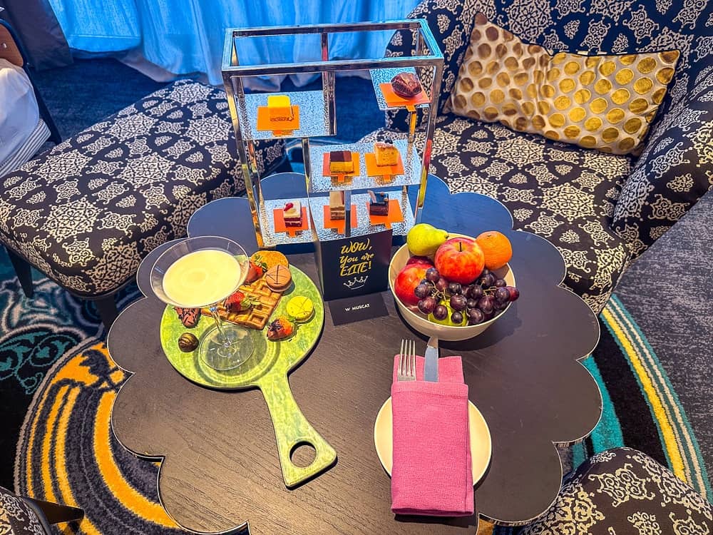 Salon panoramique du w muscat avec fauteuils noirs, baies vitrees et vue mer donnant sur terrasse et piscine