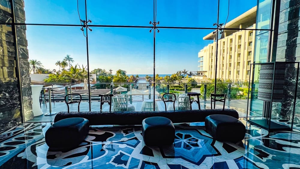 Lounge du w muscat avec table zebra, fauteuils roses vifs et plafond design dans un style contemporain audacieux