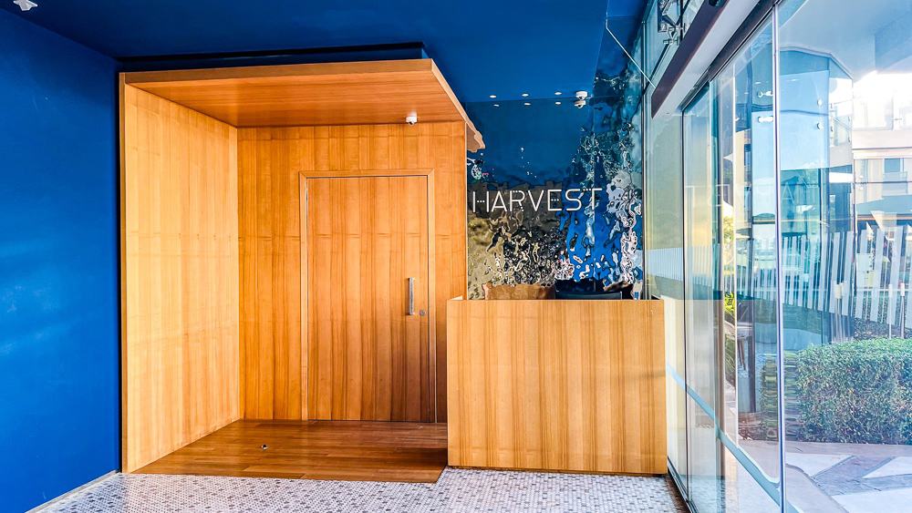 Entree du restaurant Harvest au w muscat avec mur bleu, mobilier en bois et design contemporain elegant