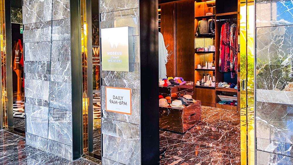 Boutique et spa du w muscat avec meubles en bois, marbre et eclairage dore dans un cadre luxueux