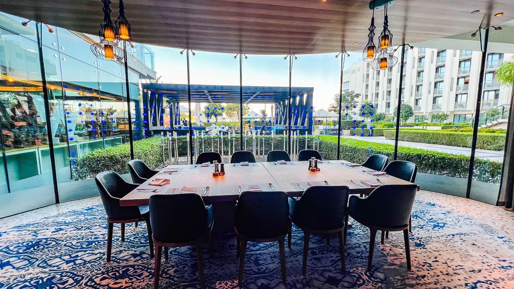 Terrasse couverte du restaurant w muscat avec vue sur les jardins et espaces extérieurs