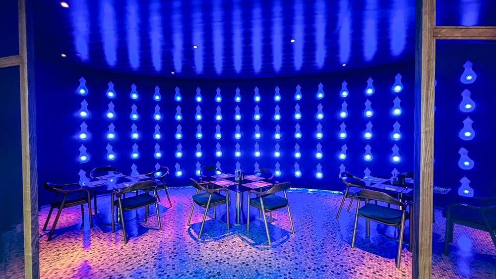 Salon privé du restaurant w muscat avec éclairage LED bleu et tables intimes