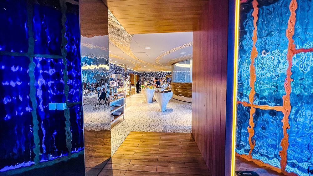 Entrée du restaurant principal du w muscat avec murs artistiques bleus et design contemporain