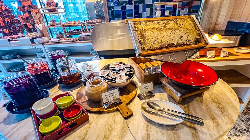 Station petit déjeuner avec miel en rayon et confitures artisanales au restaurant buffet du w muscat