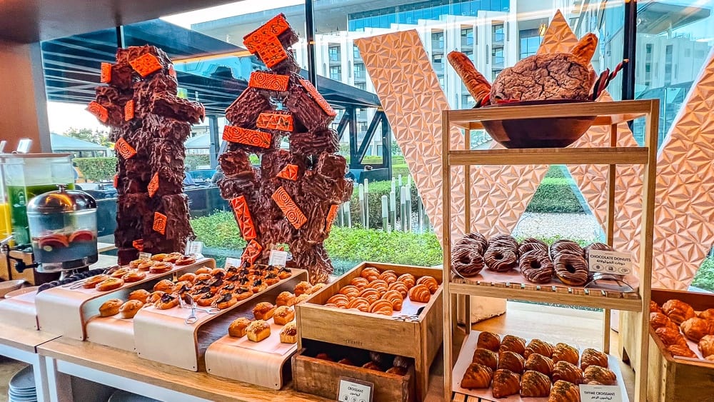 Display artistique de patisseries au w muscat avec sculptures chocolat formant le logo W et selection de desserts gourmets