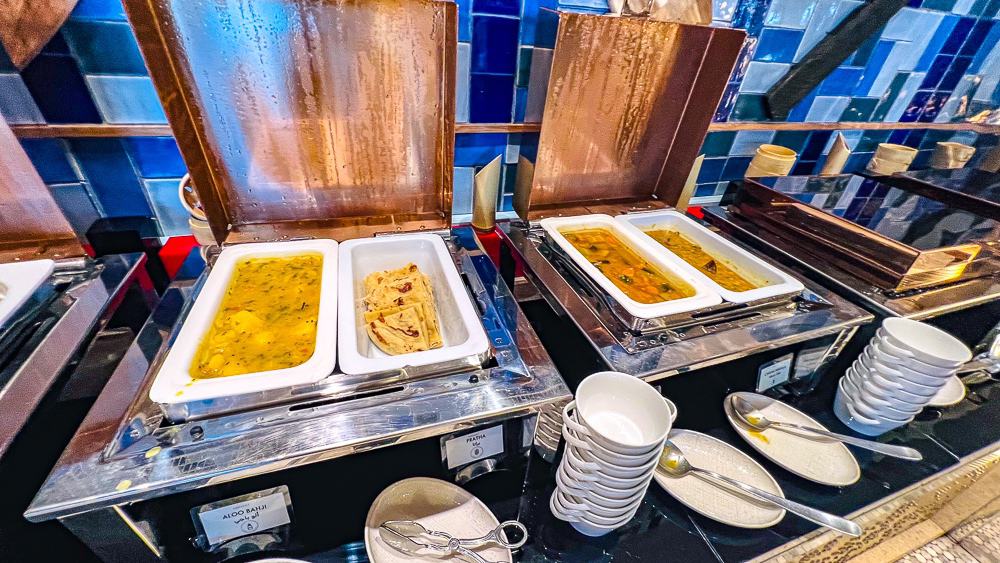 Buffet design du w muscat avec mosaiques bleues, chafing dishes cuivre et presentation moderne des plats chauds varies