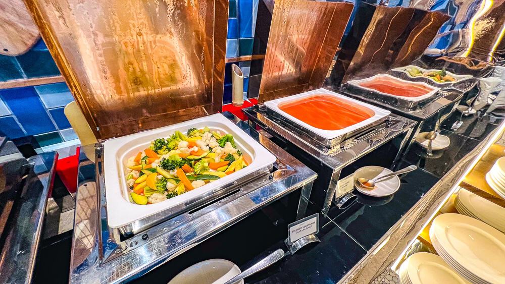 Plats chauds orientaux au buffet du w muscat avec curry de legumes et nouilles dans un decor moderne aux tons cuivres