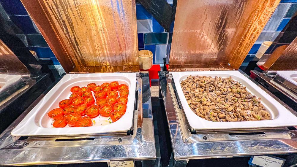 Buffet legumes grilles du w muscat avec tomates cerises et champignons sautes dans des chafing dishes design bleu