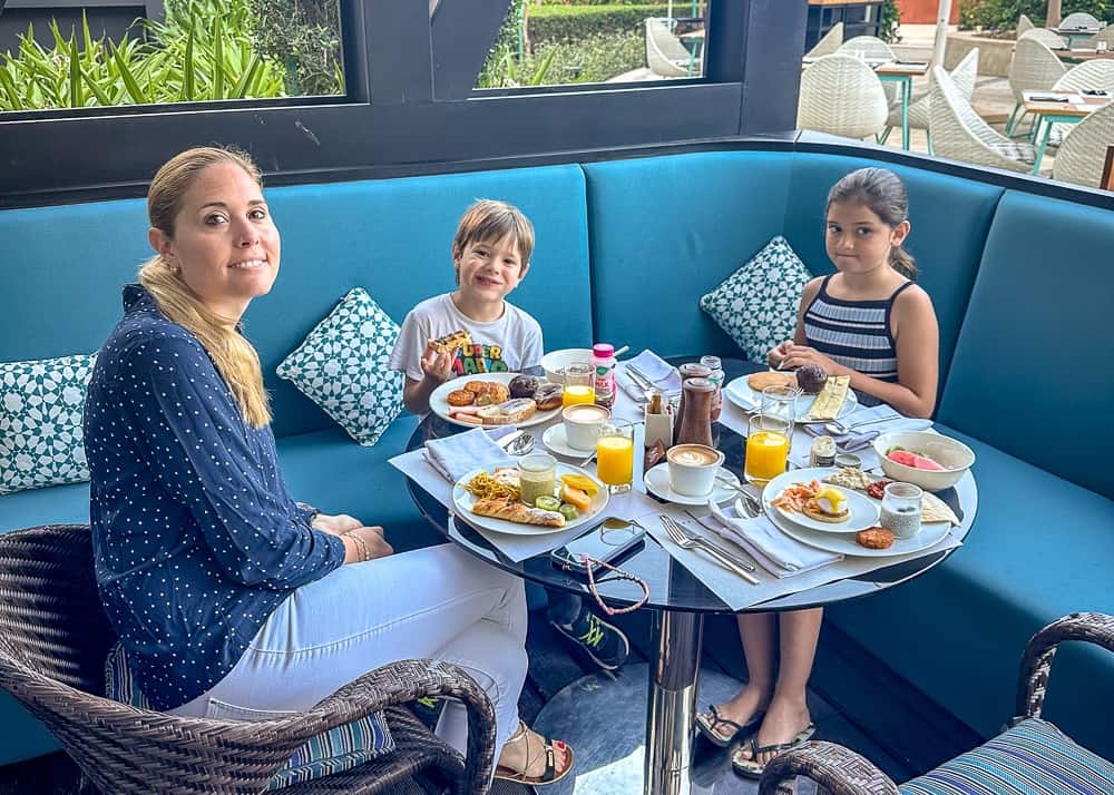 Famille prenant le petit dejeuner au restaurant du w muscat avec banquettes bleues et vue sur l'exterieur lumineux