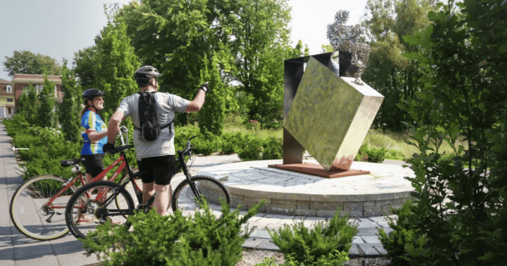 Deux cyclistes regardent une oeuvre d'art