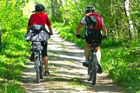 Deux personnes font du vélo sur un sentier ensoleillé