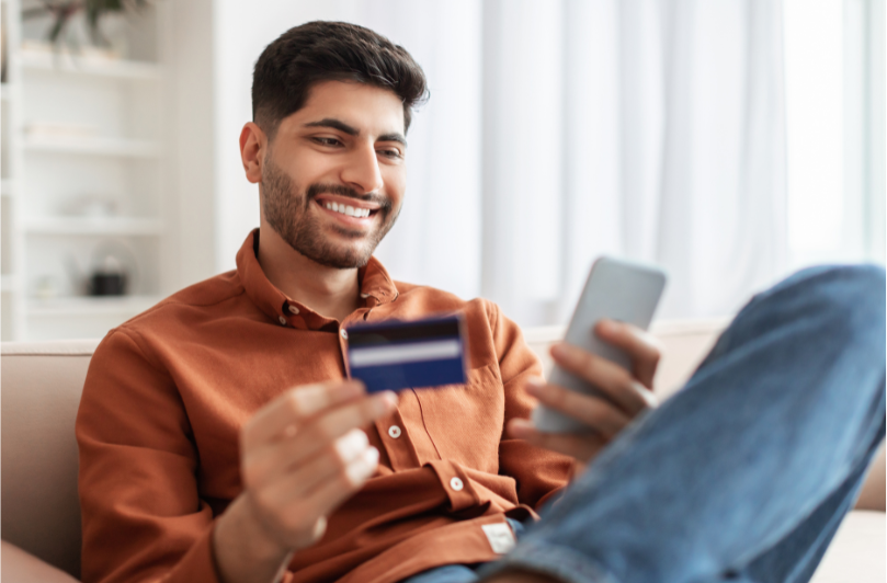 Best CC for newcomers man sitting down with credit card and phone