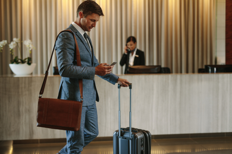 Vancouver airport shuttle featured image man with suitcase in hotel lobby