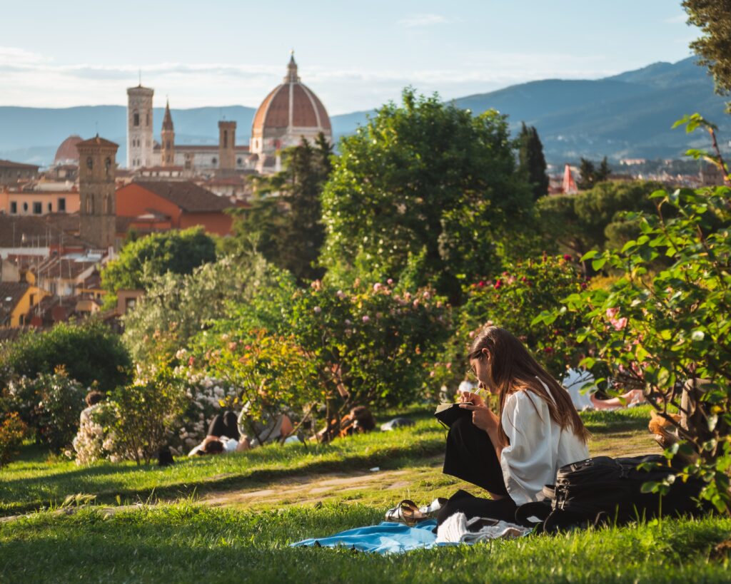 Girl sitting on the grass with a beautiful view of Florence at the background