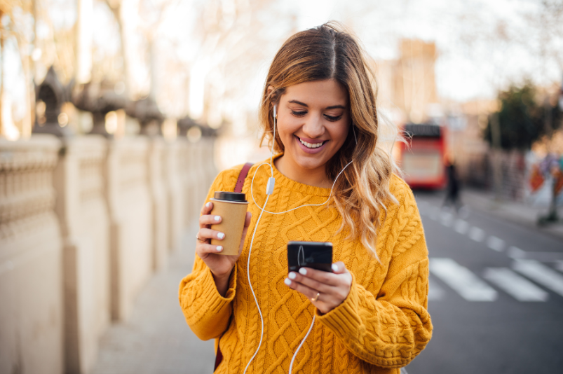 femme marchant avec téléphone et café