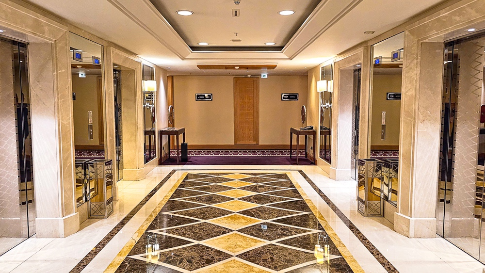 Hall d'ascenseurs luxueux en marbre du JW Marriott Hotel Ankara avec sol geometrique et eclairage elegante