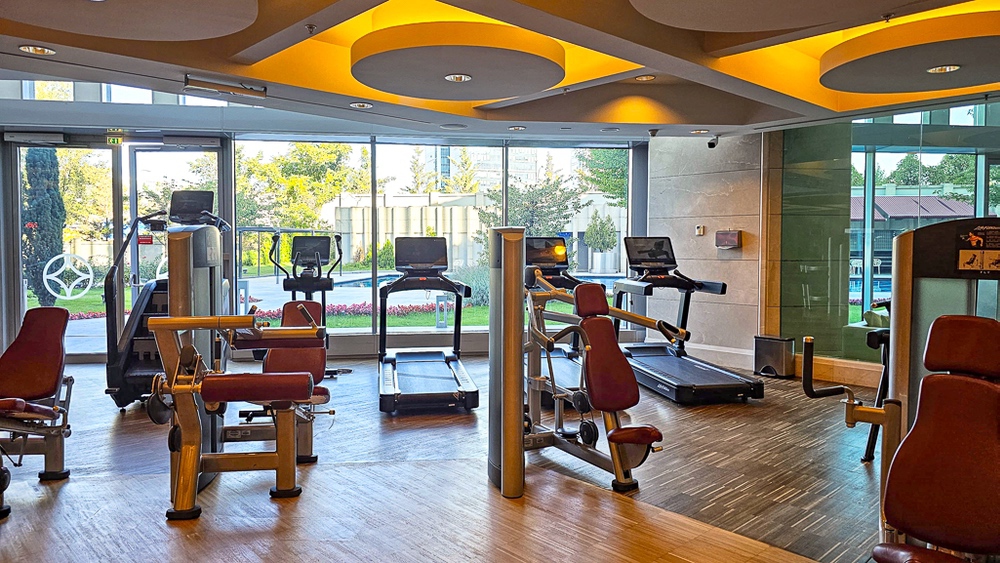 Salle de fitness moderne avec equipements cardio et vue jardin au JW Marriott Hotel Ankara, plafond design