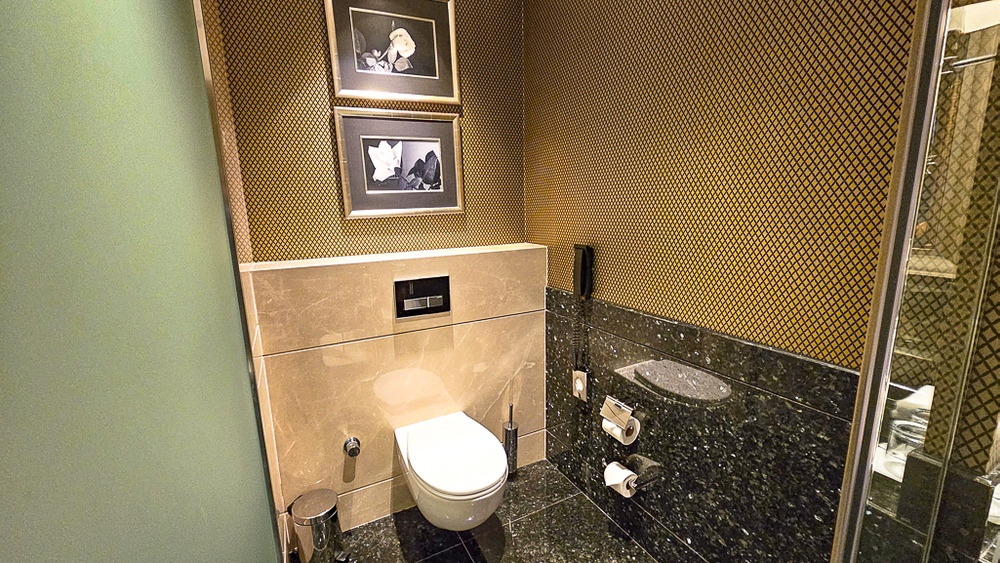Toilettes design avec papier peint doré et vasque moderne dans la suite du JW Marriott Hotel Ankara