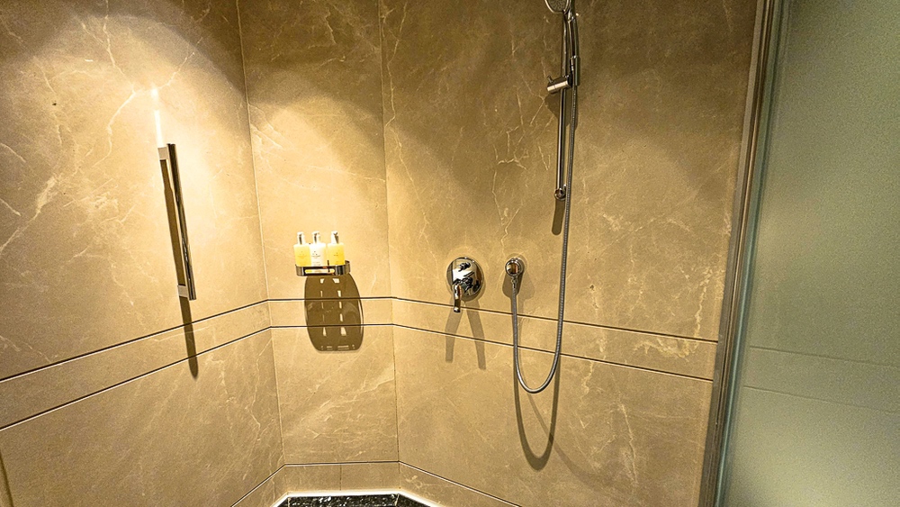 Douche italienne en marbre beige de la salle de bain au JW Marriott Hotel Ankara avec robinetterie moderne chromée